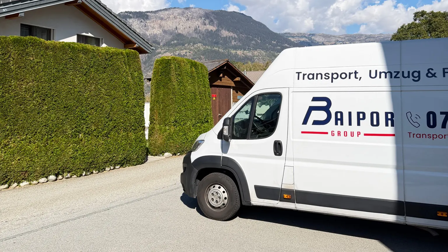 Beschrifteter Transporter der Baipor Group in der Schweiz, mit Bergen im Hintergrund